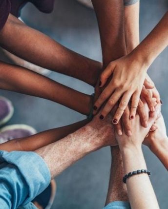 a team with their hands together in the center of a circle