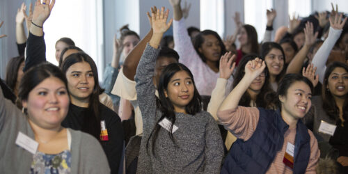 Students in the audience raising their hands.