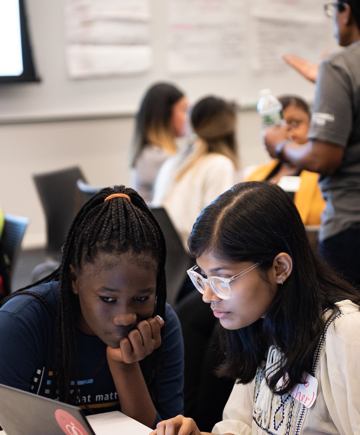 Close up on two students working together on a computer.